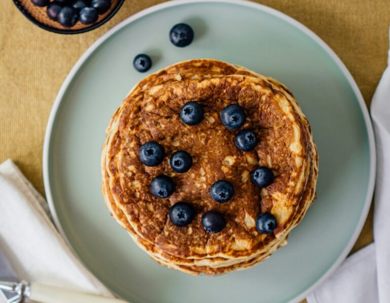 A stack of blueberry-oatmeal pancakes on a light turquoise plate