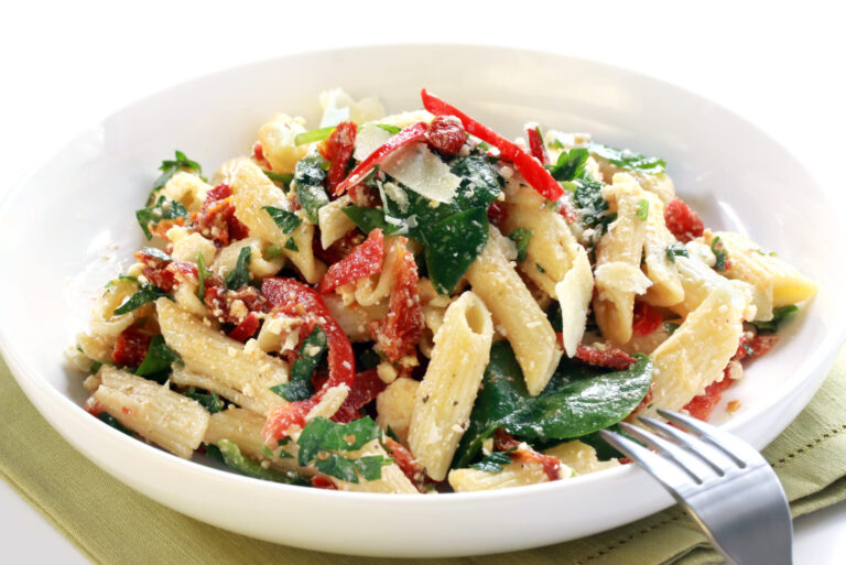 Mediterranean pasta salad made with rotini, served in a shallow white bowl