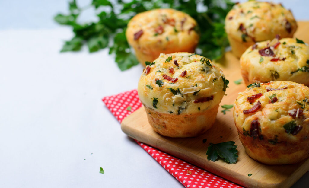 Ham and cheese muffins placed on a cutting board on top of a red napkin