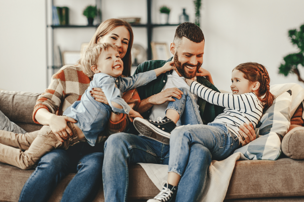 family on the couch laughing and looking happy