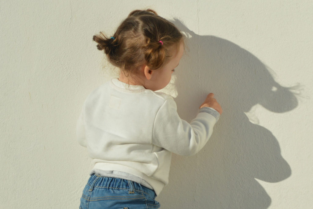 little girl standing in the corner alone