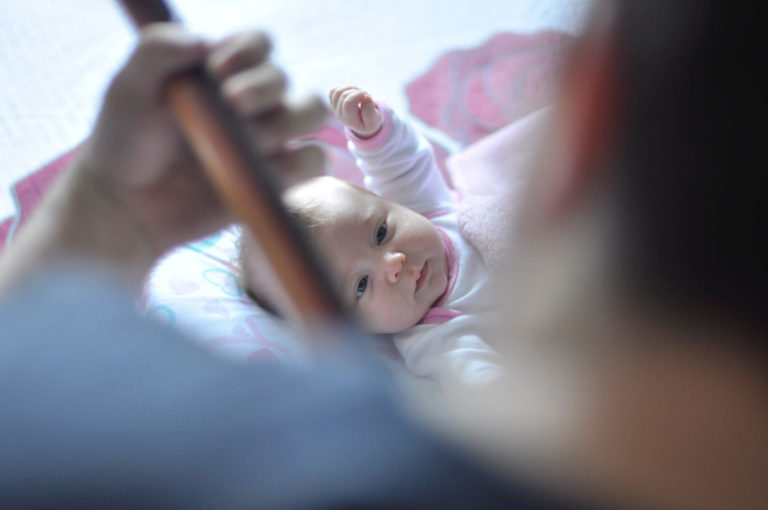 baby looking up at dad playing guitar