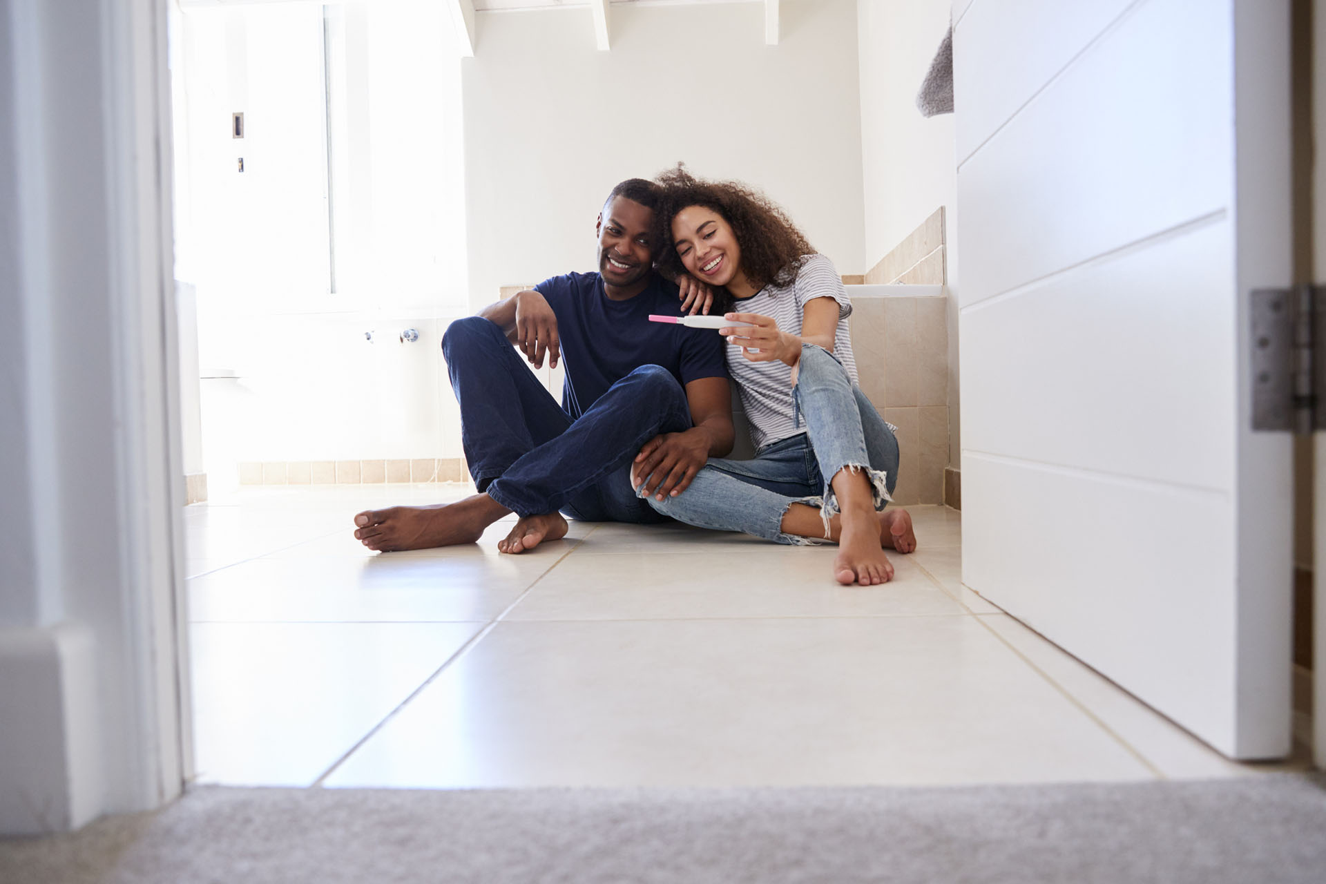 a couple sits with positive pregnancy test