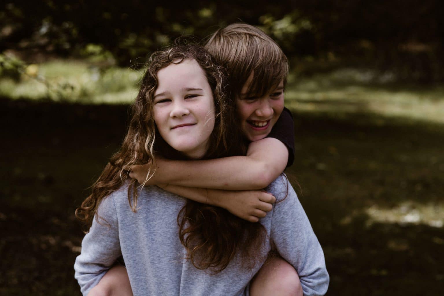 girl giving boy a piggy back ride
