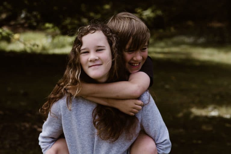 girl giving boy a piggy back ride