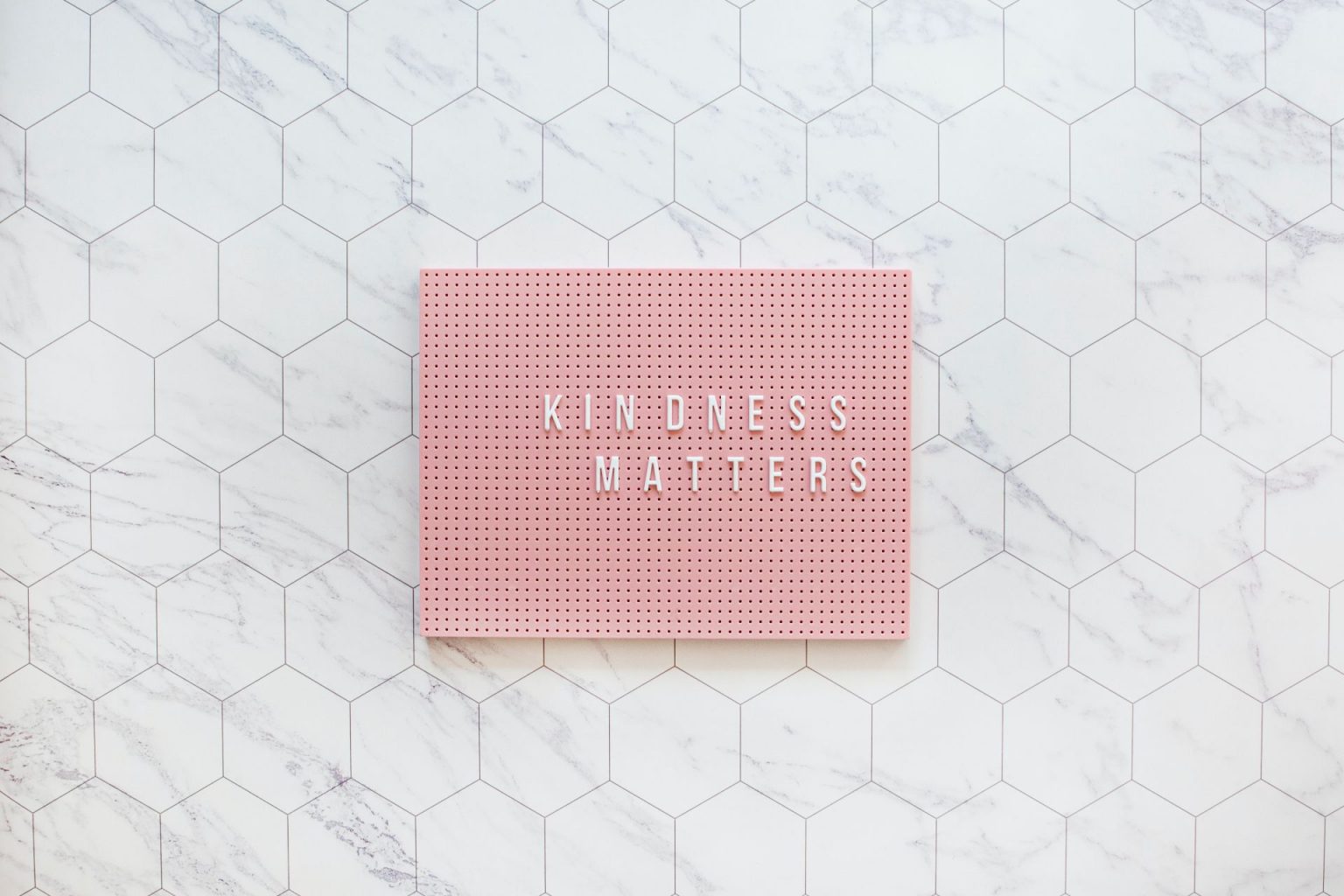 "Kindness matters" written on a pink plaque, to illustrate ways to show kindness
