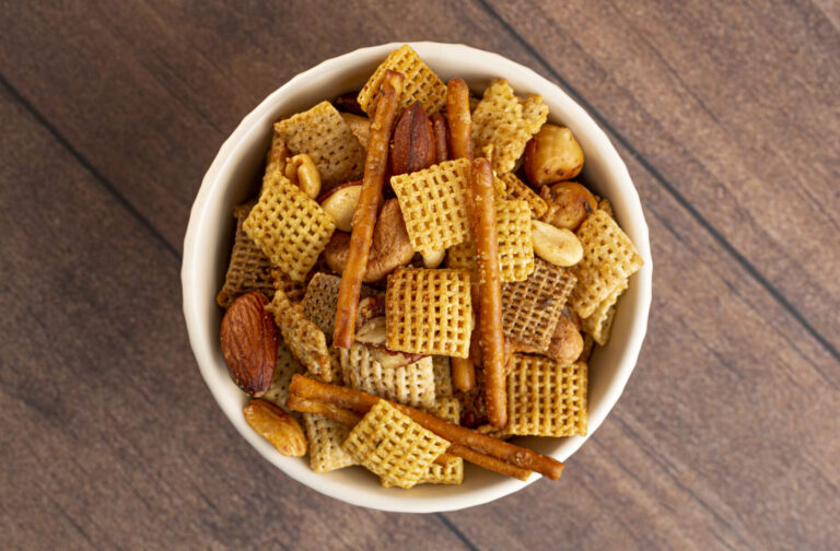 Classic nuts and bolts in a white bowl on a wooden surface