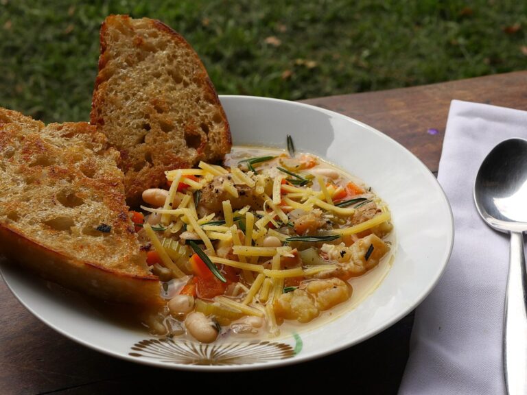 White bean and roasted potato soup served in a shallow, white bowl with two pieces of toasted sourdough