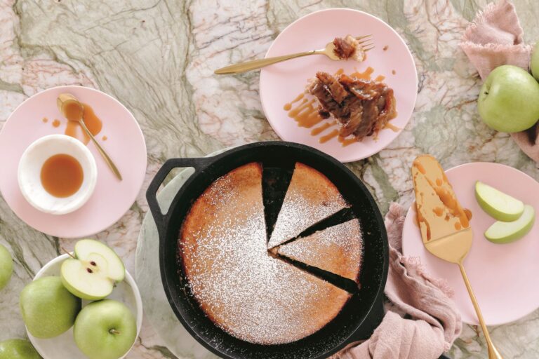 A deep dish apple pancake is sliced and ready for plating