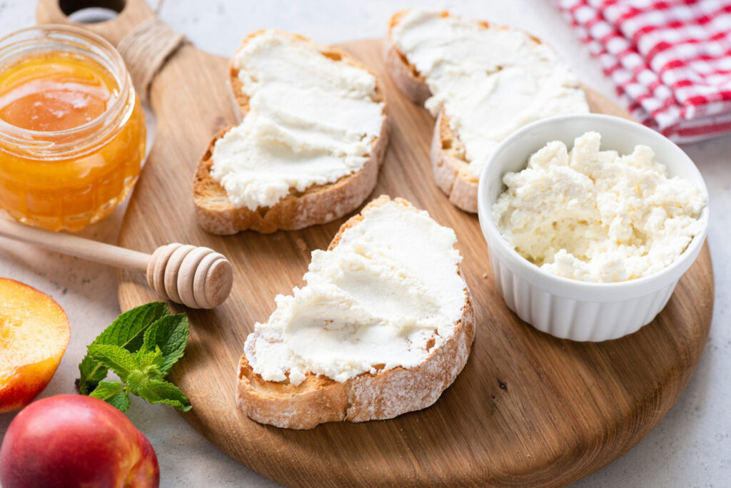 Toast with ricotta spread on a wooden cutting board