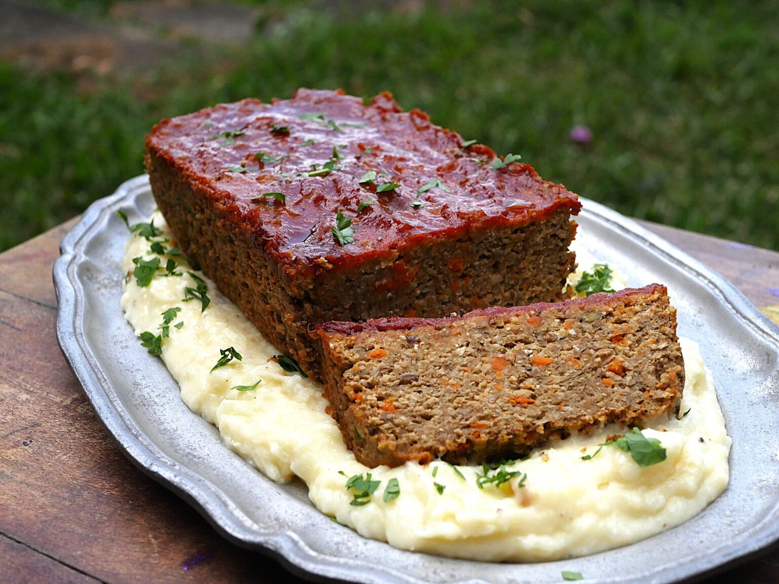 Lentil loaf with creamy roasted garlic mashed potatoes on a blue platter