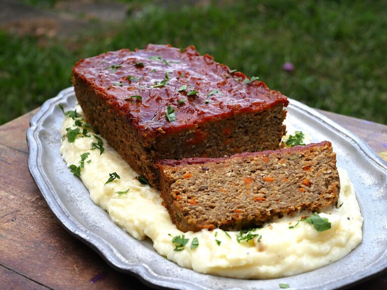 Lentil loaf with creamy roasted garlic mashed potatoes on a blue platter